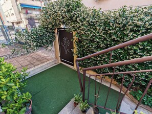 A gated entrance with a decorative door, a green artificial turf area, and potted plants. - KAIXIN'S HOUSE (Private garden + 15-minute bus ride to Venice) (Venezia)