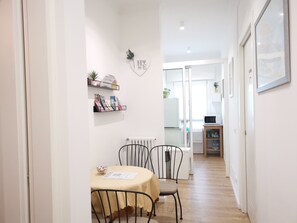 A narrow hallway with a dining table and chairs, a radiator, and a microwave in the background. - KAIXIN'S HOUSE (Private garden + 15-minute bus ride to Venice) (Venezia)