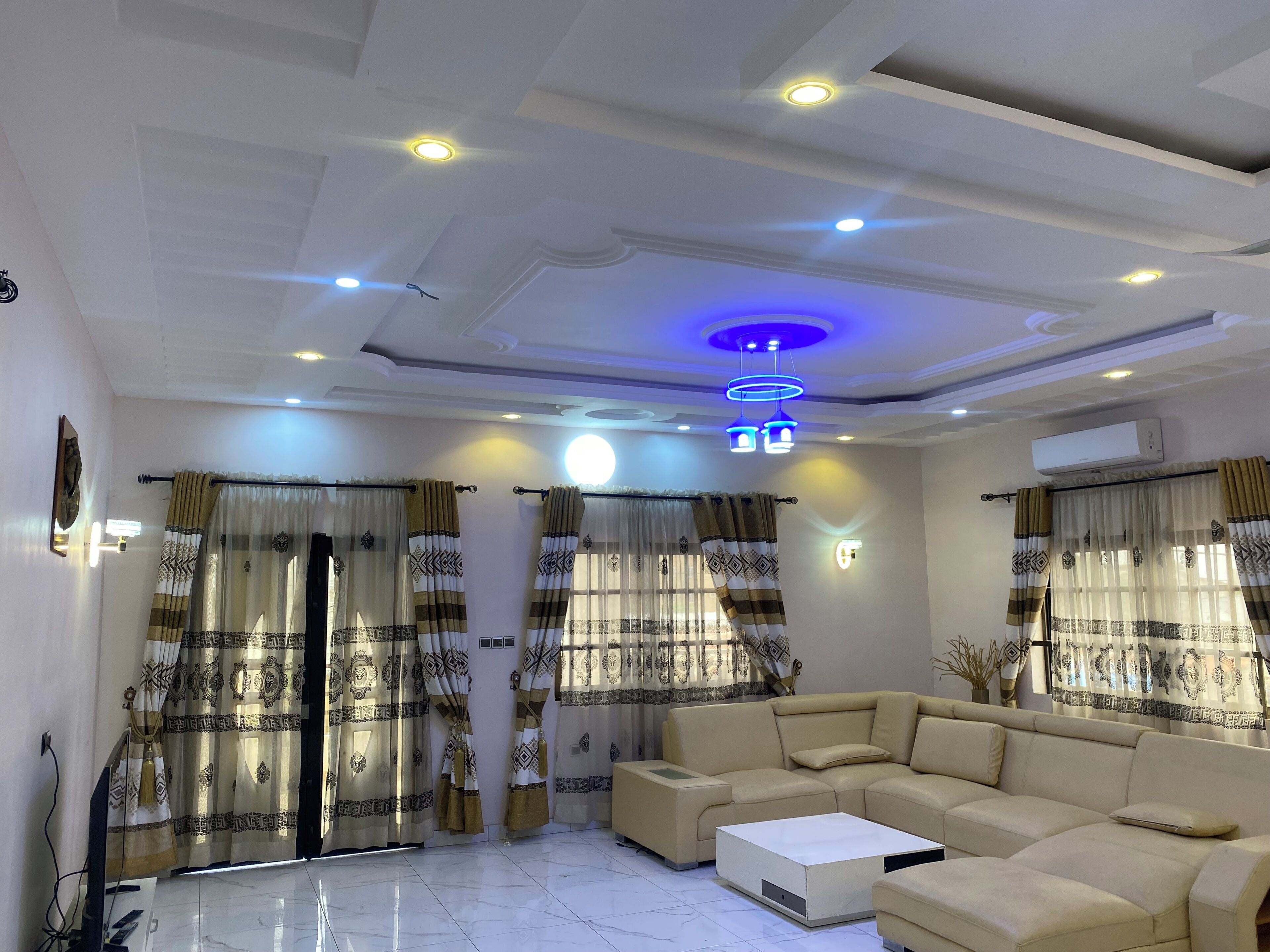 A living room with a sofa, a coffee table, and curtains with a geometric pattern.