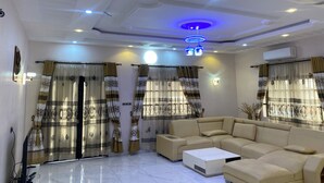 A living room with a sofa, a coffee table, and curtains with a geometric pattern. - Seemingly luxurious & peaceful (Godomey)