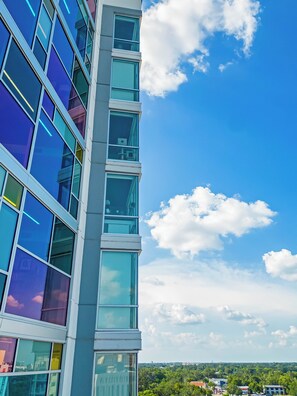A modern building with multiple floors and large windows. - The Emma - Luxury 1BR Condo King Bed, Pool, Gym (Orlando)