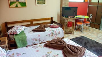 Una camera da letto con un letto, una scrivania, una sedia e un televisore.