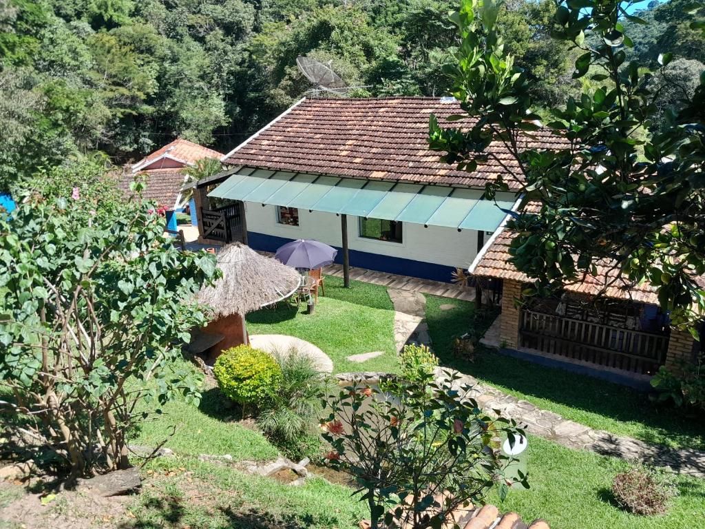 A house with a tiled roof, a thatched roof structure, and a well-maintained garden.