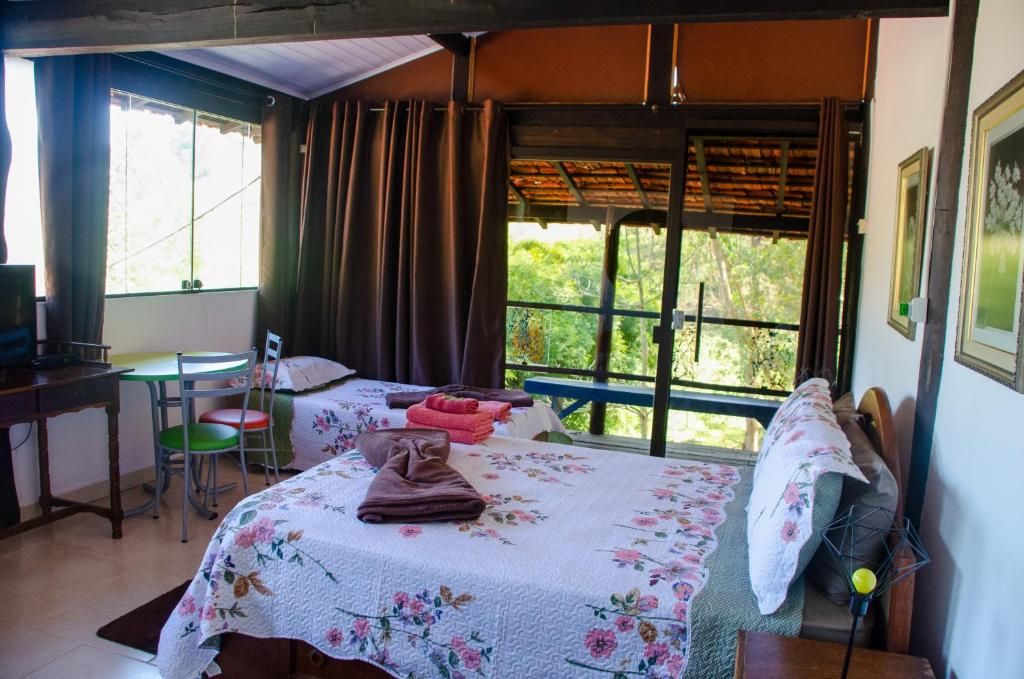 A room with a bed, a desk, a chair, and a window with curtains.