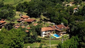 Zona residencial amb diverses cases, piscina i vegetació abundant.