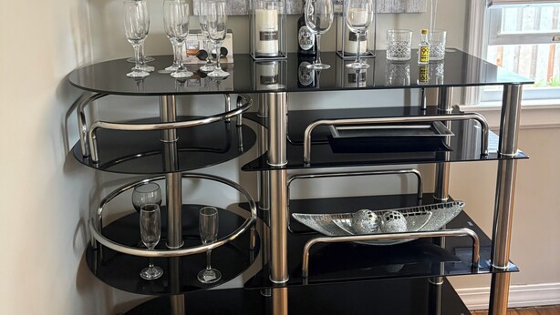 A modern, multi-tiered black bar with glass shelves, wine bottles, and glasses. - 2-bedroom bed & breakfast in nice Syracuse with front fenced in yard (Syracuse)