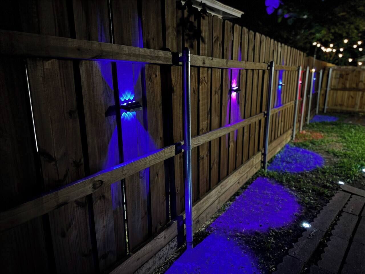 Une clôture en bois avec des luminaires verticaux.