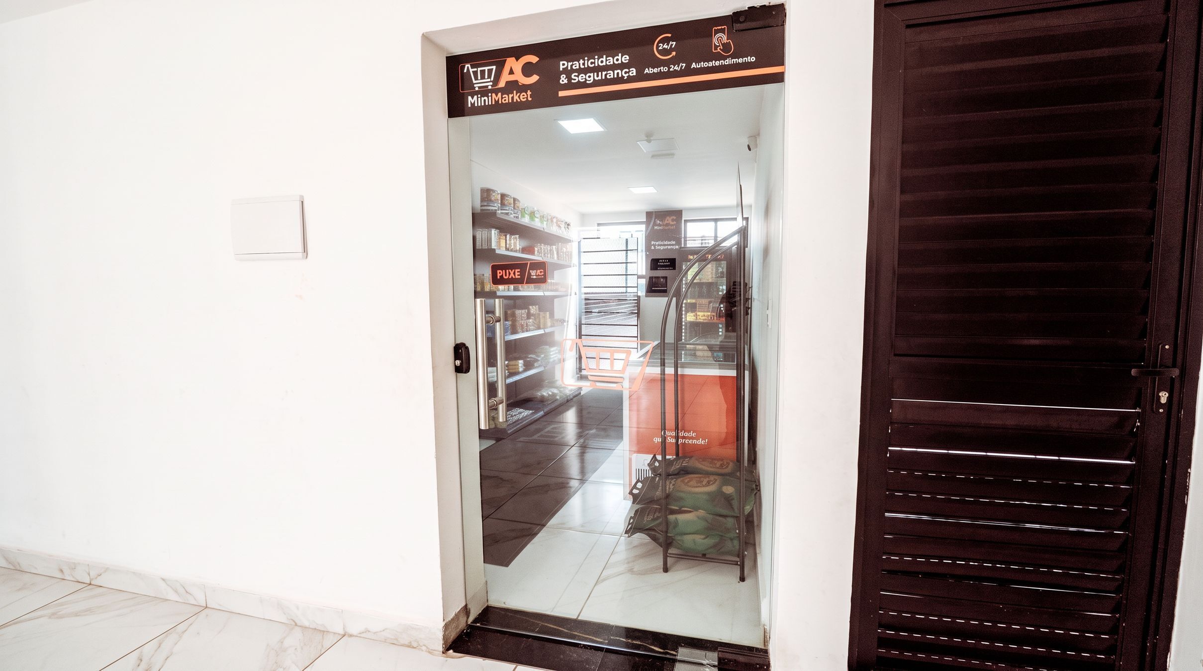 A MiniMarket entrance with a glass door, a metal staircase, and a tiled floor.