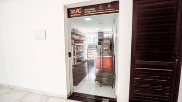 A MiniMarket entrance with a glass door, a metal staircase, and a tiled floor.