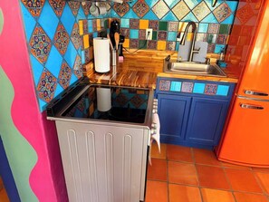 A kitchen with a microwave, sink, and colorful tiles. - Posada Linda - 4 separate suites 2m to downtown! (Las Cruces)