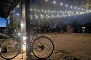 A bicycle parked outside a building with string lights overhead. - Posada Linda - 4 separate suites 2m to downtown! (Las Cruces)