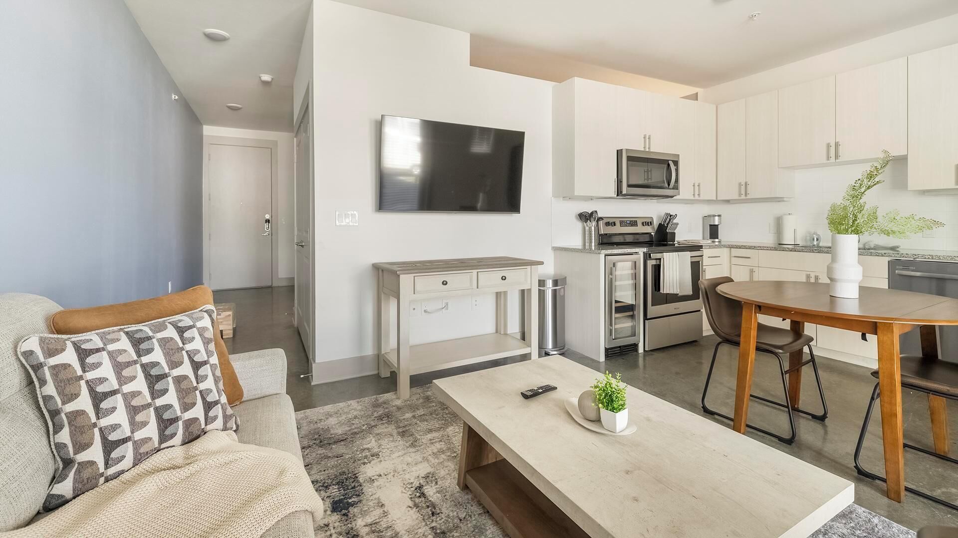 A modern apartment with a living room, kitchen, and dining area.