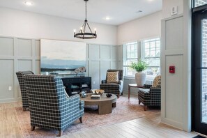 A living room with a large painting, a chandelier, and a view of the outdoors through the windows. - Landing Stylish 1bd, Gym (Beaufort)