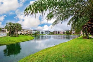A hotel with a water feature, palm trees, and a clear sky. - Seaside At Anastrasia A102 Go Coastal (St. Augustine)
