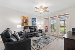 A living room with a sofa set, a coffee table, and a ceiling fan. - Seaside At Anastrasia A102 Go Coastal (St. Augustine)