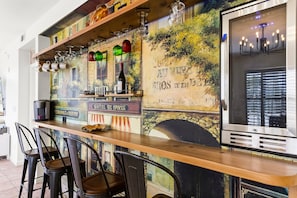 Un espace bar agrémenté d’une fresque murale, de tabourets et d’une machine à café.