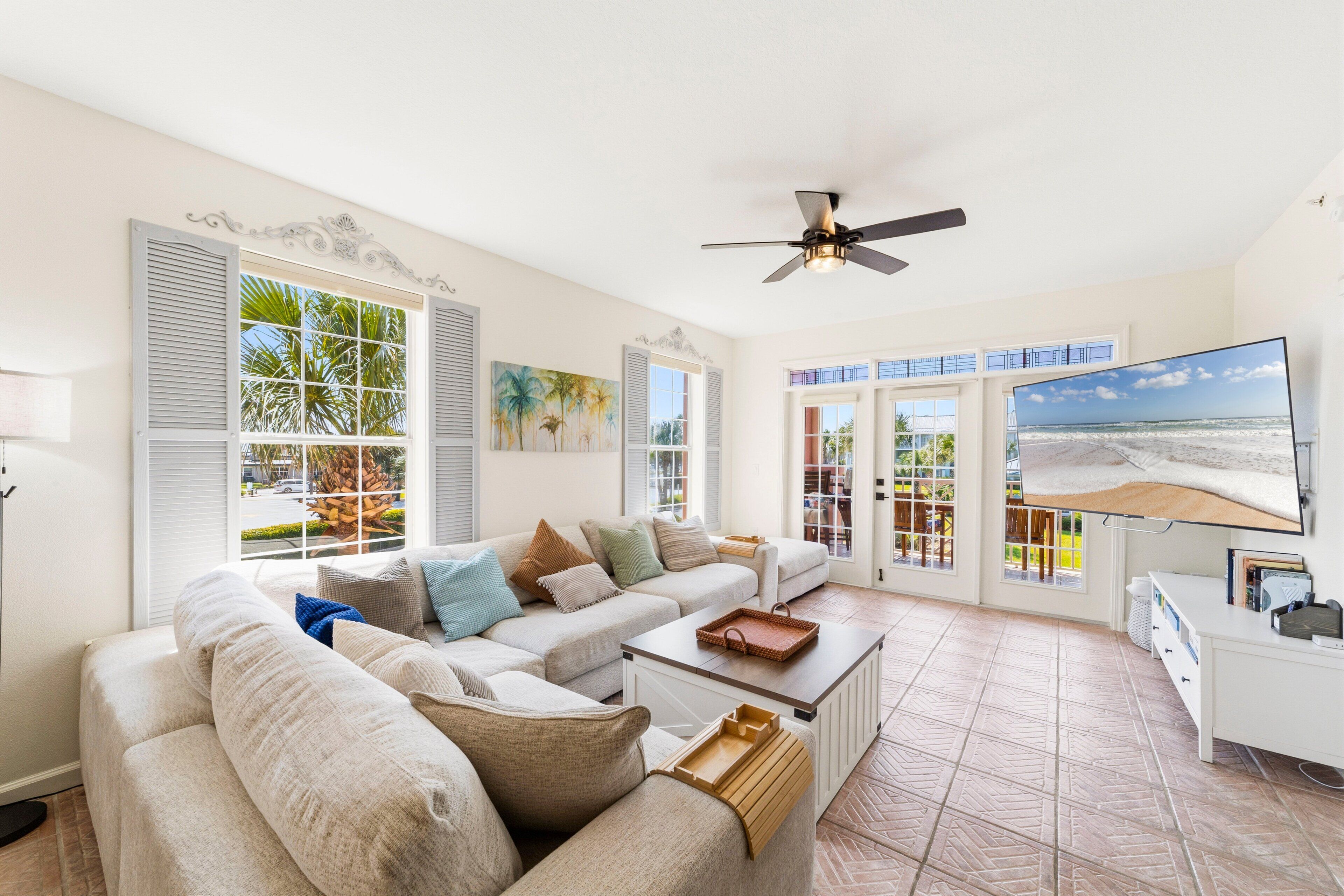 A spacious living room with a large sofa, a coffee table, and a television.