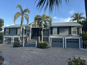 A two-story house with a covered front porch, a driveway, and a garage.