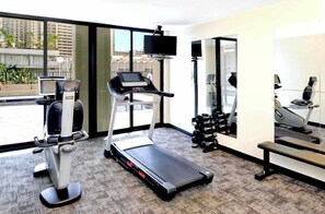 A gym with cardio equipment, dumbbells, and a treadmill. - Waikiki Escape Steps from the Beach (Honolulu)