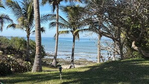 A grassy area with palm trees and a view of the ocean. - Pueblo Bonito Emerald Bay Resor, Mazatlan (Mazatlán)