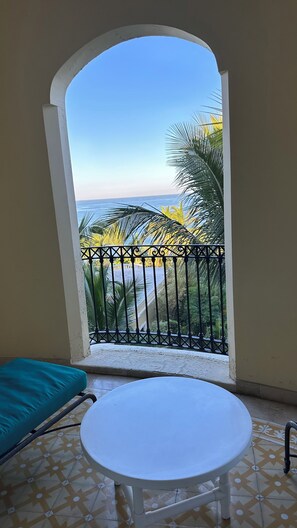 A balcony with a view of the sea, a white table, and a teal chair. - Pueblo Bonito Emerald Bay Resor, Mazatlan (Mazatlán)