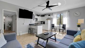 A modern living space with a kitchen, dining area, and seating area.