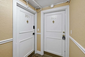 Two white doors with numbers 301 and 315, a white wall, and a beige floor. - Downtown Jacksonville Retreat Walk to Events & Stadium (Jacksonville)