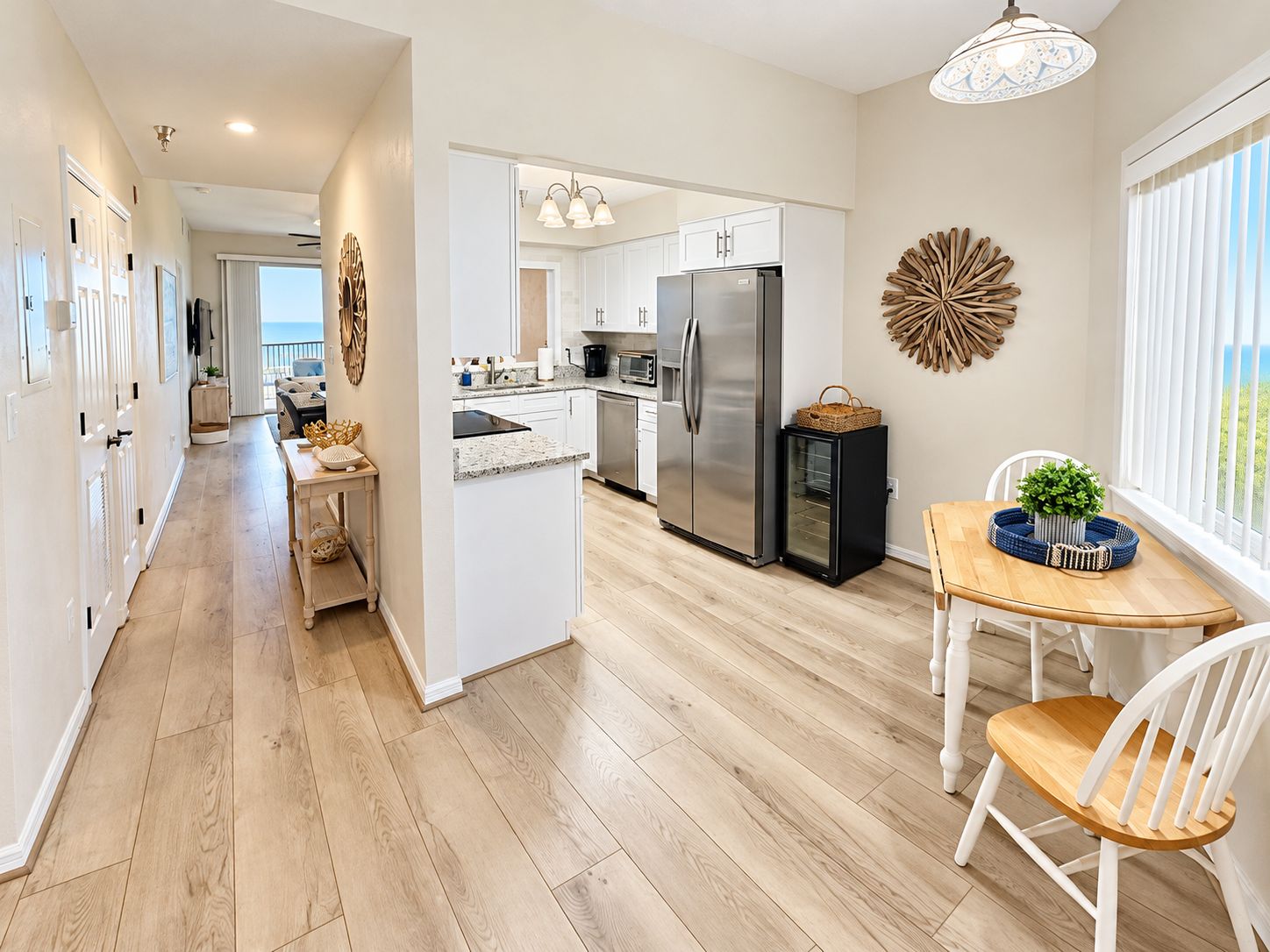 A modern kitchen with a central island, stainless steel appliances, and a dining area with a view.