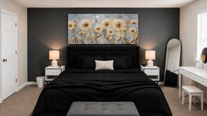 Ein Schlafzimmer mit einem großen Bett, Nachttischen, einer Bank, einem Schminktisch und einem Spiegel.