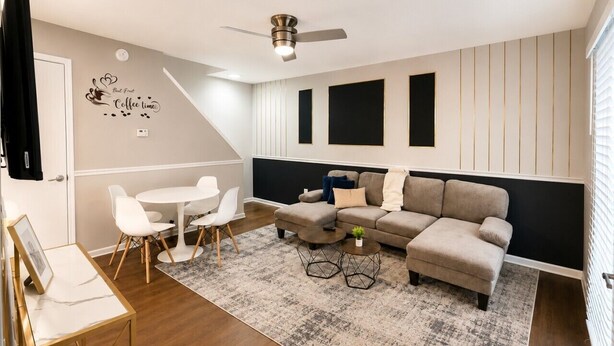 Ein modernes Wohnzimmer mit einer Couch, einem Couchtisch und Sesseln.