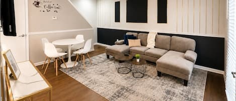 A modern living room with a sofa, coffee table, and chairs.