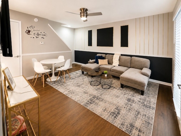 Un salon moderne avec un canapé, une table basse et des fauteuils.
