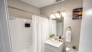 Ein Badezimmer mit Badewanne, Toilette, Waschbecken und Duschvorhang.