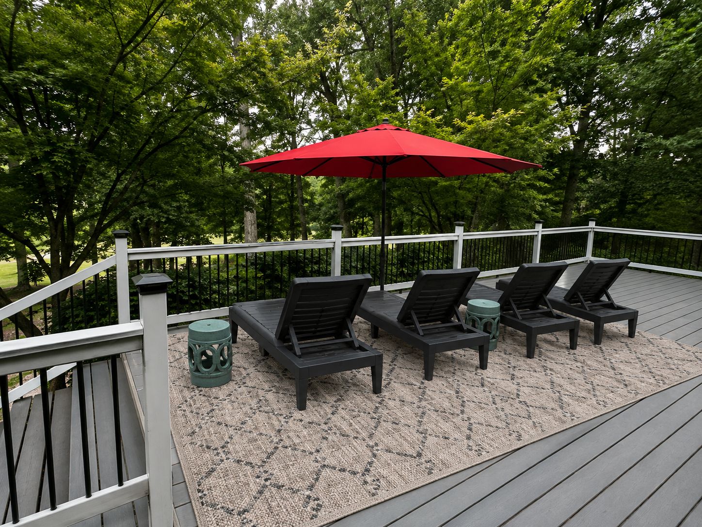 Eine Terrasse mit Gartenmöbeln und einem roten Sonnenschirm.