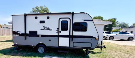 Una caravana blanca con una franja negra, un logotipo y el modelo 'SLX'.