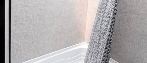 Un baño con tragaluz, bañera y retrete.