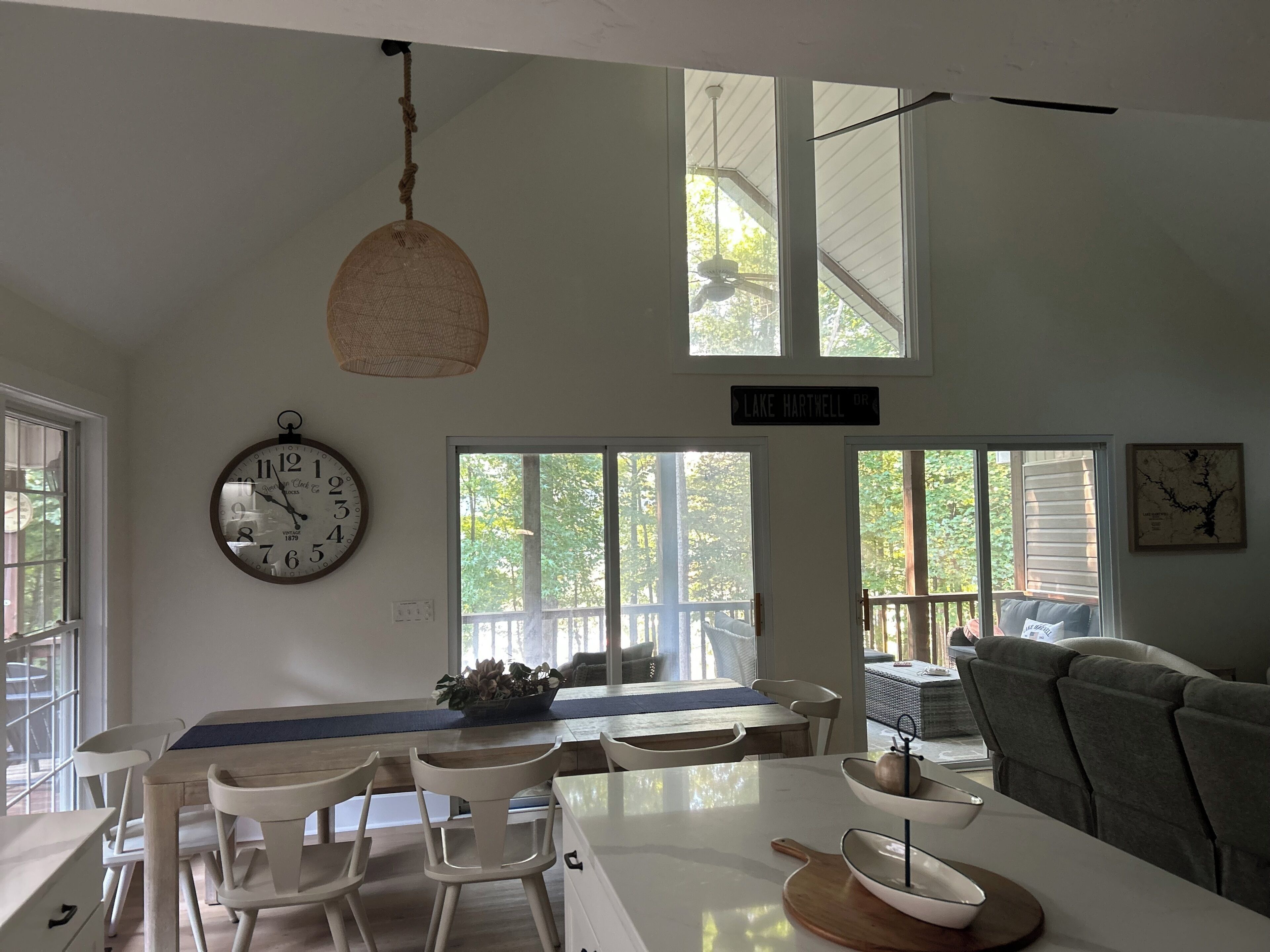 Una cocina moderna con comedor, ventanas amplias y un reloj en la pared.