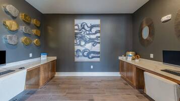 A reception area with a modern design, featuring a central abstract painting, a mirror, and a decorative wall piece.