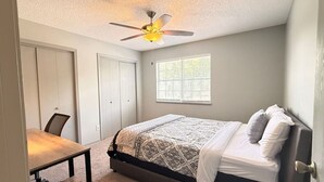 A bedroom with a bed, a desk, a chair, a ceiling fan, and a window. - Top Stay in a Perfect Location – Crystal Bridges (Bentonville)