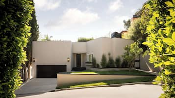 A modern house with a garage, a small front yard, and a driveway.