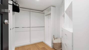 A room with a wooden floor, white walls, and a door with a metal handle.
