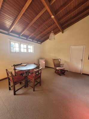 A room with a wooden ceiling, a round table with chairs, a refrigerator, and a door. - Cozy house, close to the center of Canela. 4 bedrooms and pets allowed. (Canela)
