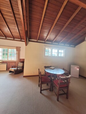 A room with a wooden ceiling, a round table with chairs, a radiator, and a refrigerator. - Cozy house, close to the center of Canela. 4 bedrooms and pets allowed. (Canela)