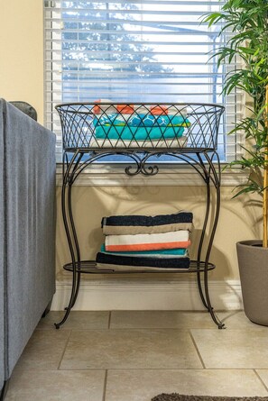 A metal rack with folded towels and a potted plant beside it. - Orlando Escape! Pool-Spa-Theater-GameRoom:4-15 PPL (Davenport)