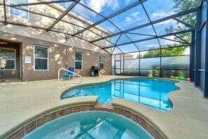 Une piscine intérieure dotée d’un toit en verre, d’une chaise longue et d’un barbecue.