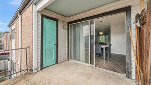 A residential property with a sliding glass door leading to a dining area with a table and chairs. - Chic Houston Apt 2BR 2BA (Houston)