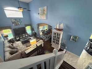 A living room with a sofa, TV, and a dining area with chairs and a table. - Peaceful Backyard Paradise (Haines City)