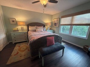 A bedroom with a bed, bedside tables, a bench, a ceiling fan, and a window with blinds. - Peaceful Backyard Paradise (Haines City)