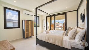 Quarto com cama grande, guarda-roupa e varanda com vista.