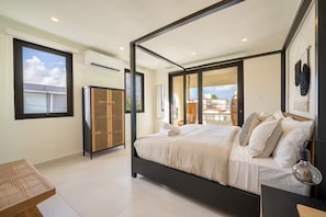 Een slaapkamer met een groot bed, een garderobe en een balkon met uitzicht.